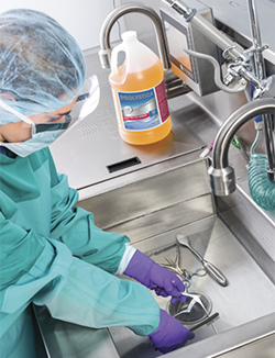 Cleaning surgical instruments at a sink.