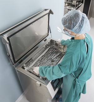 Staff member loading an ultrasonic cleaner.