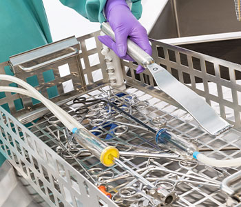 Technician Loading Surgical Instruments into Ultrasonic Washer