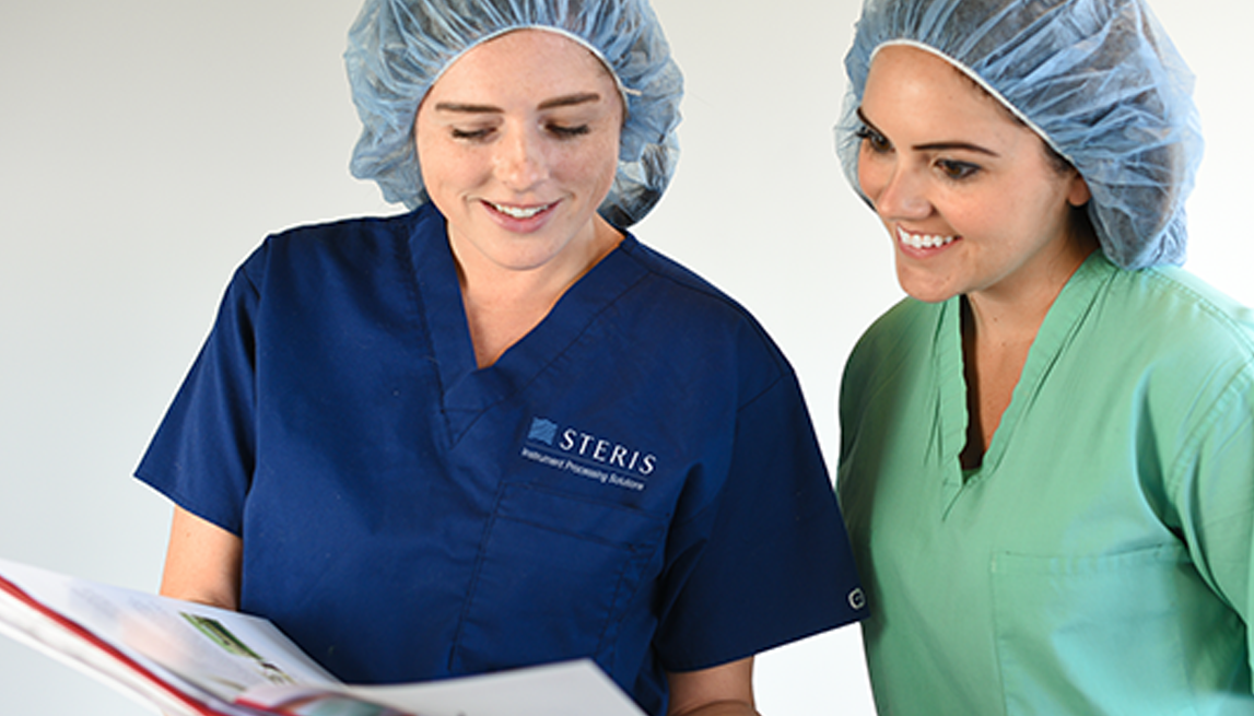 Two female Sterile Processing Department workers reviewing paperwork